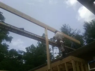 Carpenter setting a ridge beam over a new addition frame — Ice Dam Removal by Roofing Brothers in Lacey