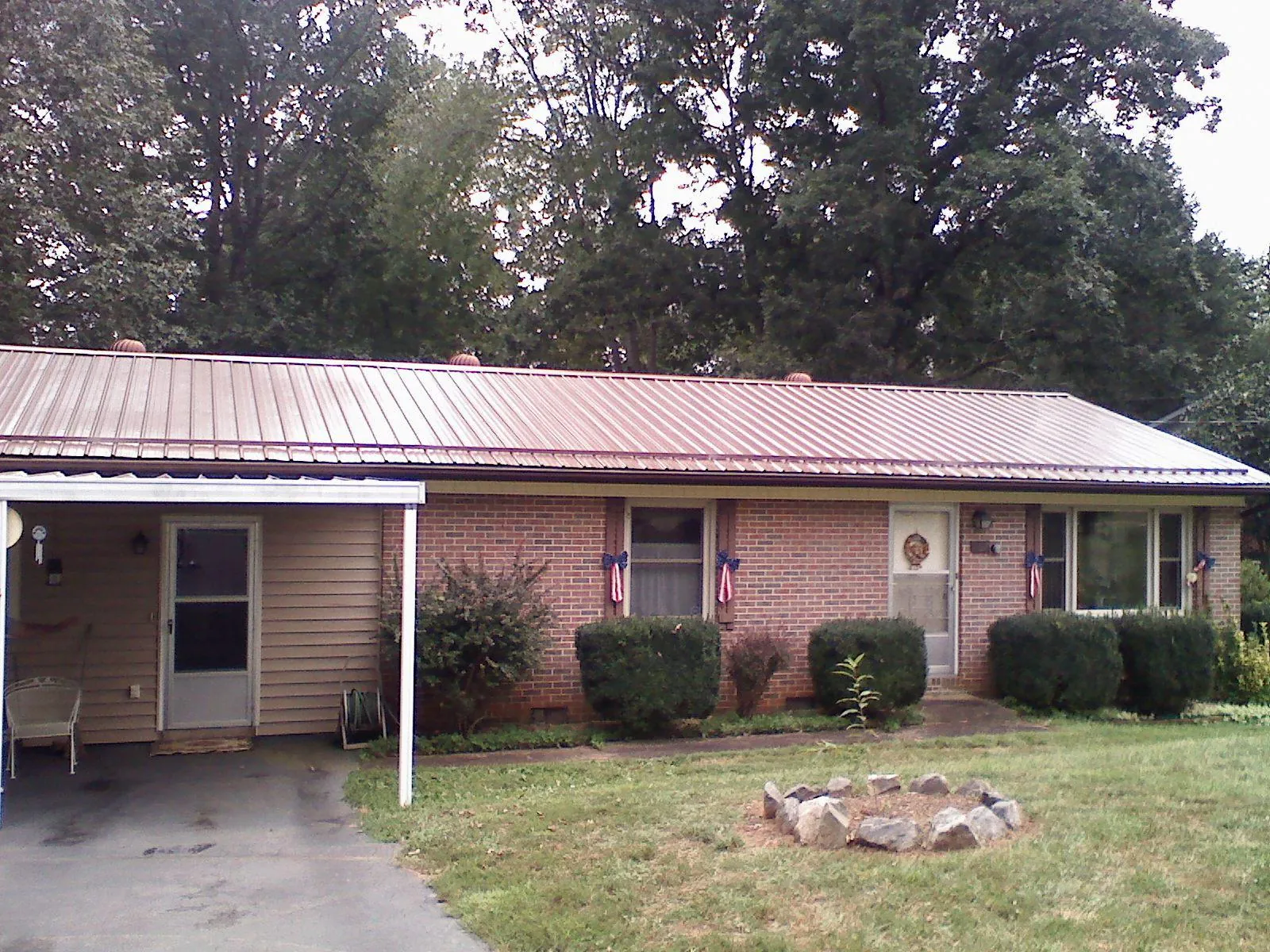 Bronze metal roof and carport on a brick ranch home — Roof Repair work by our crew in Lacey